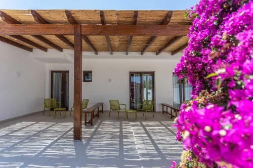 切萨雷奥港B&B Villa Massimo的一个带桌椅和紫色鲜花的庭院