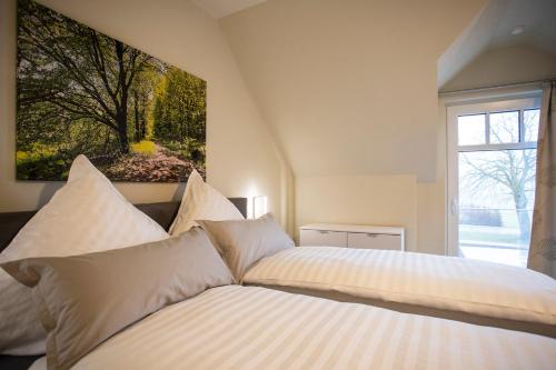 布里隆Hanses Hof的一间卧室设有两张床,墙上挂着一幅画