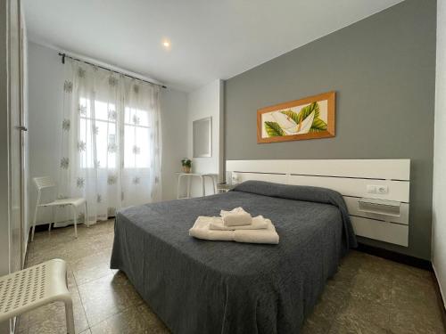 滨海托萨地中海旅馆的一间卧室配有一张床,上面有两条毛巾