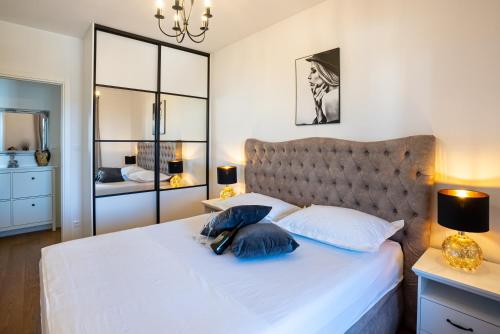 斯普利特Morska vila 6 Luxury Apartment Žnjan的卧室配有带蓝色枕头的大型白色床