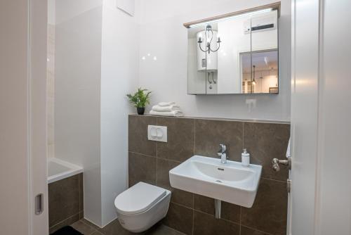 斯普利特Morska vila 6 Luxury Apartment Žnjan的一间带水槽、卫生间和镜子的浴室