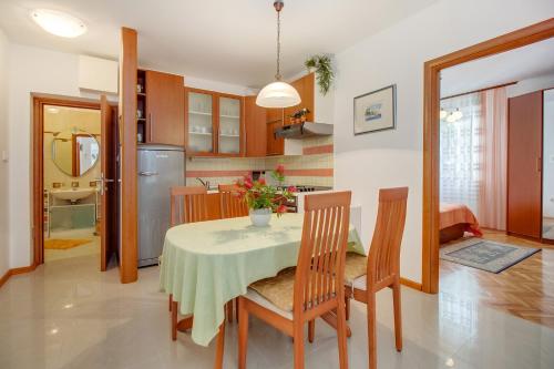 木洛希尼Apartman Mirjana 1的厨房以及带桌椅的用餐室。