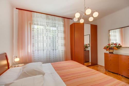 木洛希尼Apartman Mirjana 1的一间卧室设有一张大床和一个窗户。