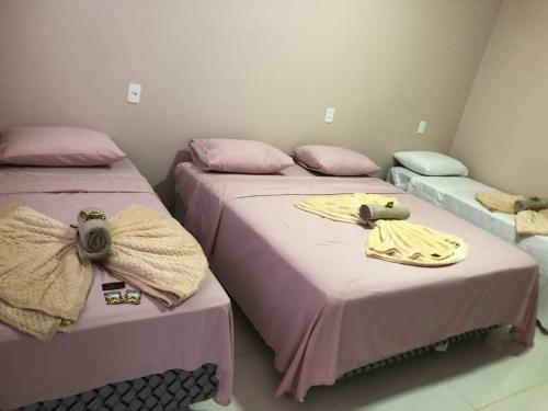 托坎廷斯州圣费利克斯Pousada Amanhecer no Jalapão的配有粉红色床单的客房内的两张床