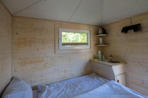 埃尔克海姆Baumhaus - Tiny Haus in der Höhe的一间小卧室,配有床和窗户