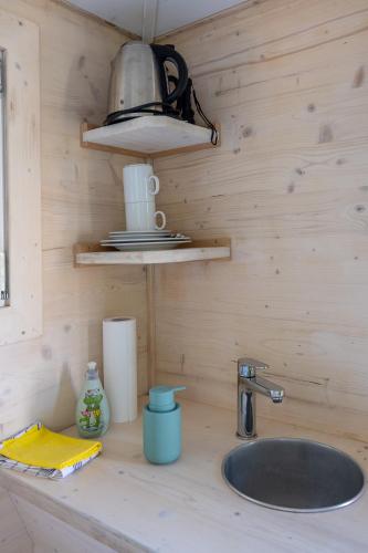 埃尔克海姆Baumhaus - Tiny Haus in der Höhe的厨房柜台设有水槽和台灯。