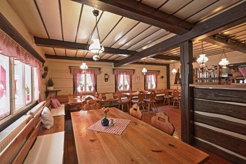 哈拉霍夫Penzion a Restaurace U Paseků的一间带木桌和椅子的用餐室