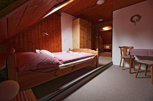 哈拉霍夫Penzion a Restaurace U Paseků的一间卧室配有一张木墙床