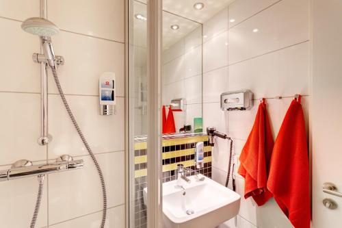 美因河畔法兰克福法兰克福机场梅宁阁酒店的一间带水槽和淋浴的浴室