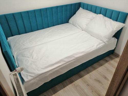 马尔堡Apartament Przy Parku的一张带蓝色床头板、白色床单和枕头的床