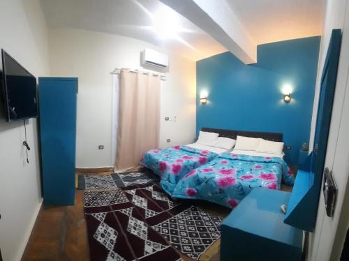 开罗happy life hostel的一间卧室设有一张床和蓝色的墙壁