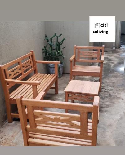 大坎普CITI COLIVING HOSTEL的两个木长椅和一张桌子,一个植物
