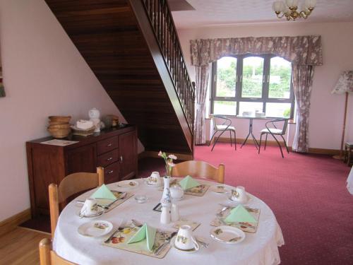 BallylongfordGreenfields Farmhouse的一间用餐室,配有一张带白色桌布的桌子