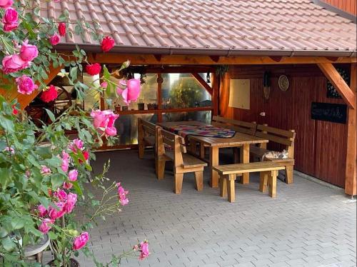 LăzareaGáll vendégház的天井配有桌子、长椅和玫瑰