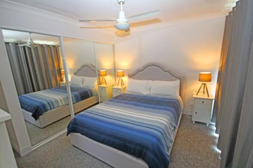 科夫斯港Paradise Waters 13的一间卧室设有两张床和大镜子