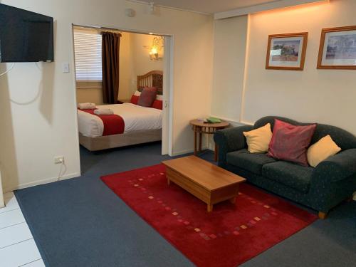 玛丽伯勒阿卡纳汽车旅馆的客厅配有沙发和1张床