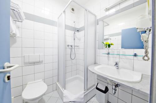 普鲁洪尼斯 潘普鲁洪尼斯图利酒店的带淋浴、卫生间和盥洗盆的白色浴室