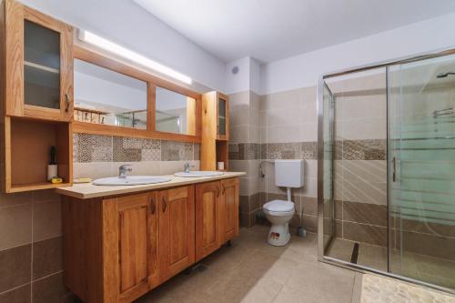 马拉亚Pensiunea Bradet的一间带两个盥洗盆和淋浴的浴室