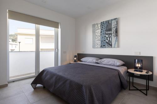 加埃塔Oneweek Gaeta Suites and Apartments的一间卧室设有一张床和一个大窗户