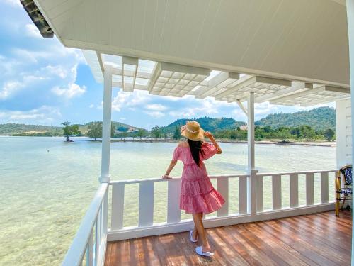 巴淡岛中心Morelo Water Villa的站在船上穿着粉红色衣服的女人