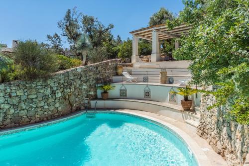 拉卡莱Tenuta Aphrodite的一座带石墙和石楼梯的游泳池