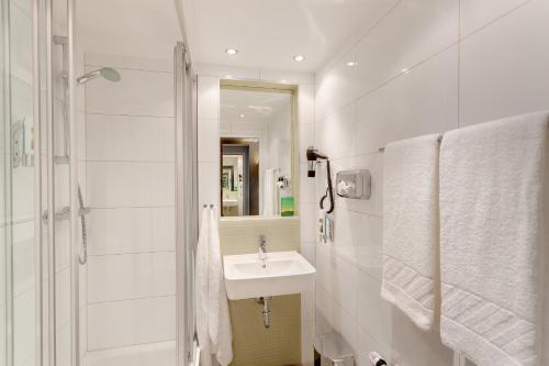 维也纳梅宁阁弗兰兹市中心酒店的白色的浴室设有水槽和淋浴。