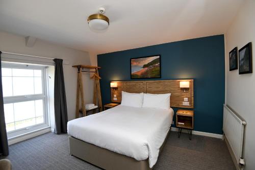 阿博波恩轮船旅馆的卧室配有一张白色大床和蓝色的墙壁