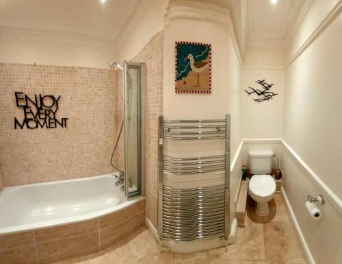 福克斯通Beautifully appointed, period seaside apartment的带浴缸、卫生间和盥洗盆的浴室