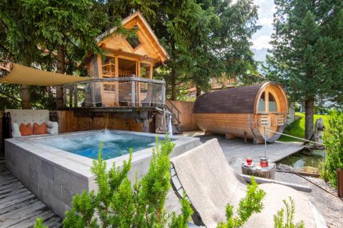 塞尔瓦迪加尔代纳山谷Chalet Elisabeth dolomites alpin & charme的后院设有热水浴池和树屋