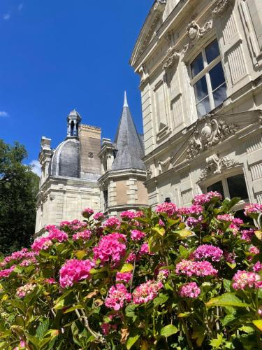 BouchemaineChâteau le Fresne的前面有粉红色花的建筑