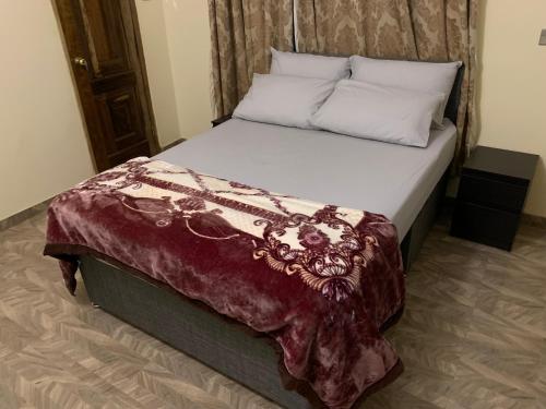 阿克拉Top Base Apartments的一间卧室配有一张大床和一张红毯
