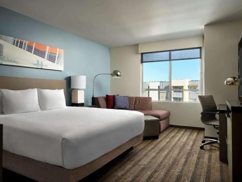 洛杉矶Hyatt House LA - University Medical Center的酒店客房设有一张大床和一张书桌。