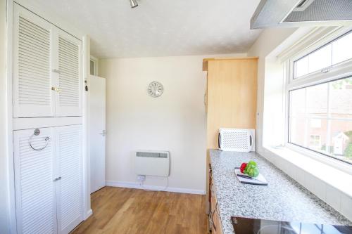 威尔汉姆West Lulworth Apartment的厨房设有白色的墙壁、窗户和柜台