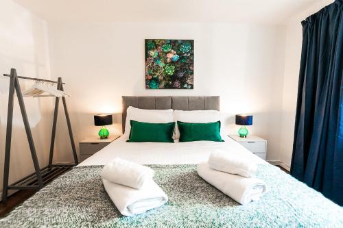 圣奥尔本斯Beech Road Apartment St Albans by PAY AS U STAY的一间卧室配有一张大床和两个绿色枕头