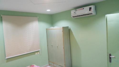 Az Zulfiاستراحة سكنية للإيجار اليومي والشهري的浴室设有绿色的墙壁、镜子和橱柜