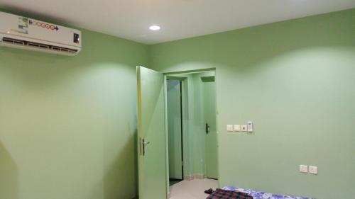 Az Zulfiاستراحة سكنية للإيجار اليومي والشهري的一间设有绿色墙壁和通往浴室的门的房间
