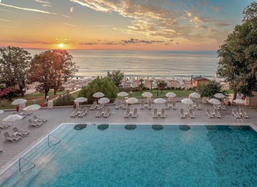金沙GRIFID Vistamar Hotel - 24 Hours Ultra All inclusive & Private Beach的享有带椅子和遮阳伞的游泳池的景色