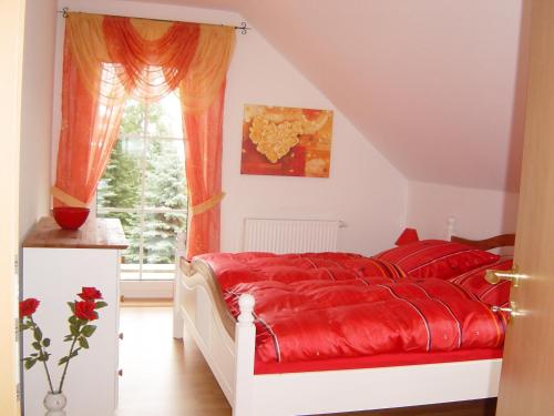 奥尔巴赫Ferienhaus Vogtlandresidenz的一间卧室设有红色的床和窗户。