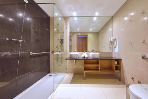 费拉古多Agua Hotels Riverside的一间带两个盥洗盆和淋浴的浴室