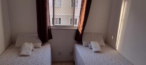 福塔莱萨Cantinho dos Rehm的客房设有两张床和窗户。