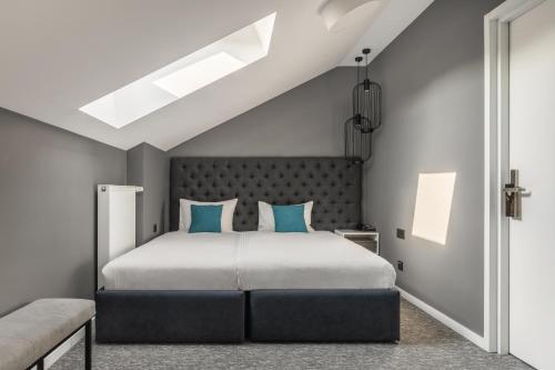 利沃夫City Inn Lviv Smart Hotel的一间卧室配有一张带蓝色枕头的大床