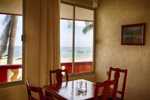 埃斯孔迪多港Rincon del Pacifico的一间设有桌子并享有海滩美景的用餐室