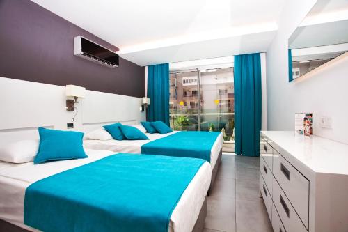 阿拉尼亚绿色花园套房酒店的两张位于酒店客房的床,配有蓝色床单