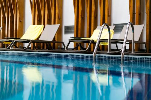 蓬塔德尔加达蓬塔德尔加达酒店的一个带两把椅子的游泳池和一个游泳池