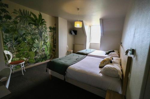 罗卡马杜尔Hostellerie Bellevue的酒店客房设有两张床,墙上挂有绘画作品