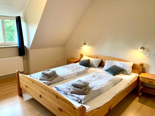 圣彼得奥尔丁Ferienwohnung 4 im Böhler Haubarg的一间卧室配有一张带毛巾的大型木床