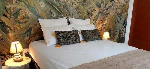 圣路易斯Les sens ciels的一间卧室配有带白色床单和枕头的床。