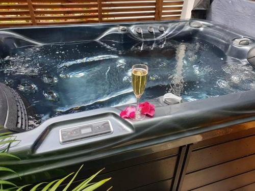 圣路易斯Les sens ciels的浴缸里放着一杯葡萄酒和一朵花