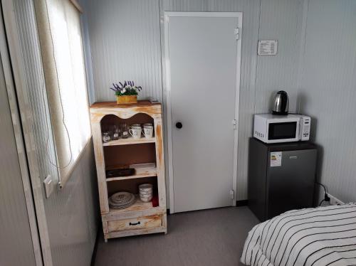 特立尼达岛Casita de Piedra Loft 7 - 8 - 9的客房设有微波炉和带冰箱的橱柜。