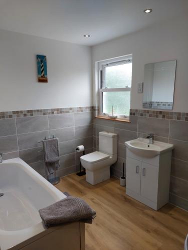 佩伦波斯Two bedroom cottage - country lane -10 min walk to Perranporth beach的带浴缸、盥洗盆和卫生间的浴室